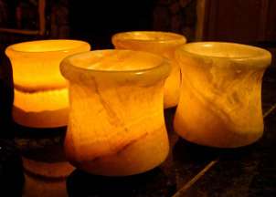 Collection of lighted Egyptian alabaster candle holders in a dark room